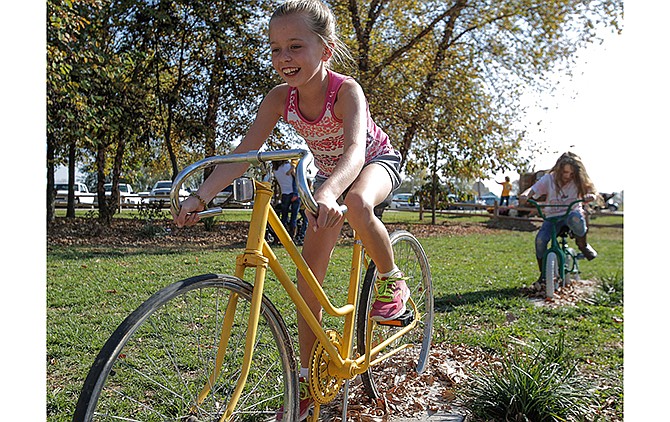 Lauren Struemph, 9, rides a stationary bike Saturday at River City Fall Festival at Cedar Island in north Jefferson City.