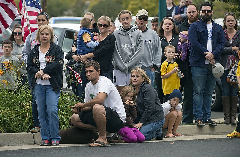 Onlookers observe silently as the body of Detective Mike Davis is escorted into the Chapel of the Valley on Vernon Street in Roseville on Saturday.