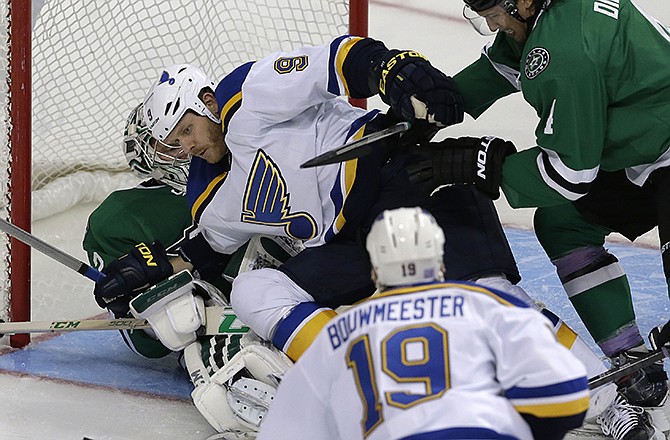 St. Louis Blues center Steve Ott (9) is pushed onto Dallas Stars goalie Kari Lehtonen (32) by defenseman Brenden Dillon (4) as Blues defenseman Jay Bouwmeester (19) looks on during the second period of an NHL hockey game, Tuesday, Oct. 28, 2014, in Dallas.