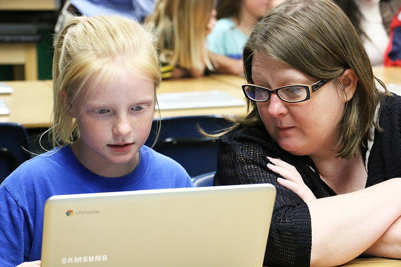 St. Peter School student Rheanna shows her mom how she has been using Google docs and a chromebook in her classes Tuesday night. The school held a technology night to show parents how they are utilizing chromebooks, which the school just bought about a month ago.