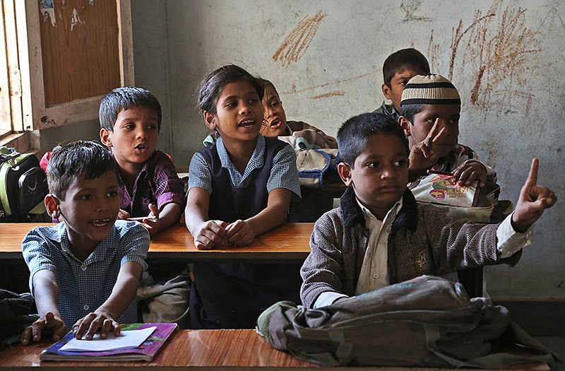 A lone schoolgirl sits among boys at a government school in Hyderabad, India.