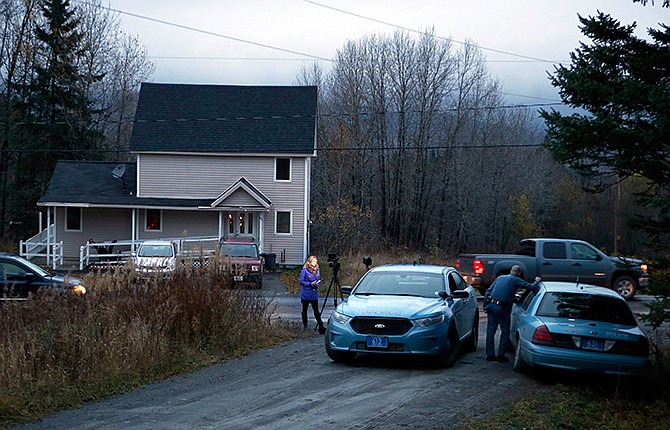 State troopers and a television reporter stand across from the home where Kaci Hickox, a nurse who treated Ebola patients in West Africa, is staying, Wednesday, Oct. 29, 2014, in Fort Kent, Maine. Hickox said Wednesday she plans to stop quarantining herself in rural Maine, signaling a potential showdown with state police monitoring her home and state officials preparing to legally enforce the quarantine. She said she'll defy the state if the policy isn't changed by Thursday.