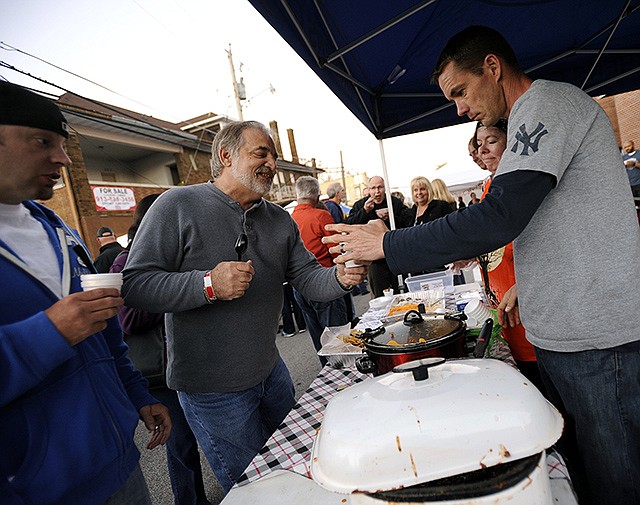 2014 FILE: Mike Landrum, center, takes a small sampling of chili from Derek Streeter while stopping at the Joe Machens Capital City Ford Lincoln tent on Ash Street during the sixth annual Big Brothers Big Sisters chili cook-off.