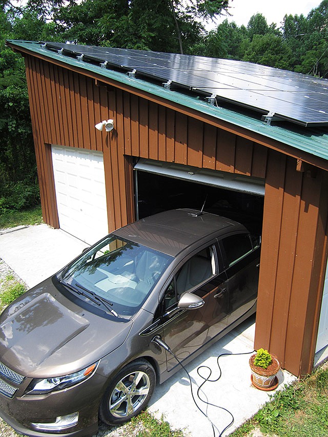 This July photo provided by Samuel Avery shows a 2014 Chevy Volt plugged in at a Hart County, Kentucky home. Avery, who is a professional solar installer, built both the garage and panel installation. A growing number of electric-vehicle owners are powering their cars with solar energy from panels on their homes.