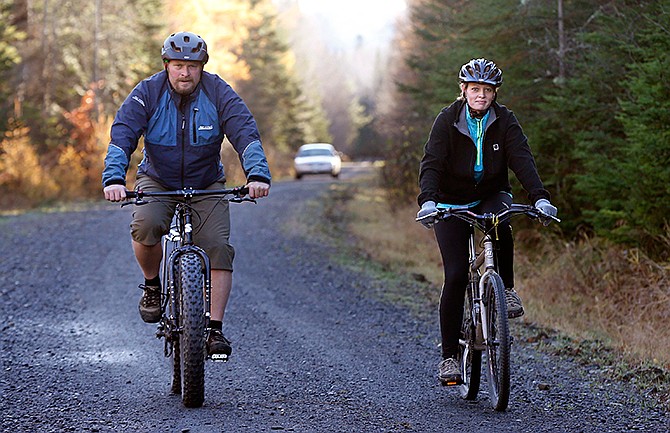 Nurse Kaci Hickox, right, and her boyfriend, Ted Wilbur are followed by a Maine State Trooper as they ride bikes on a trail near her home in Fort Kent, Maine, Thursday, Oct. 30, 2014. The couple went on an hour-long ride. 