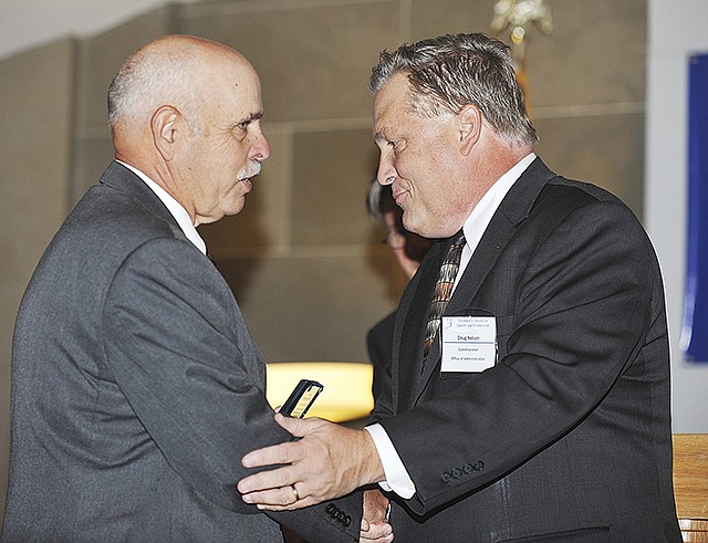 Doug Nelson, right, presents an award to Jim Keathley in the Capitol Rotunda during the 2014 Governor's Award for Quality and Productivity. Nelson is commissioner or the Office of Administration and Keathley is a member of the Frequency Acquisition Team, MO Statewide Interoperability Network (MOSWIN) that received the Technology in Government award.
