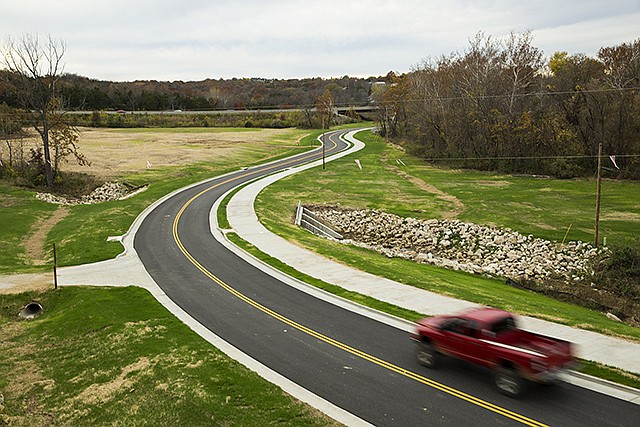 A vehicle travels along the newly-built section of road at the end of Creek Trail Drive Tuesday evening after a ribbon cutting ceremony was held to announce the official opening of the project.