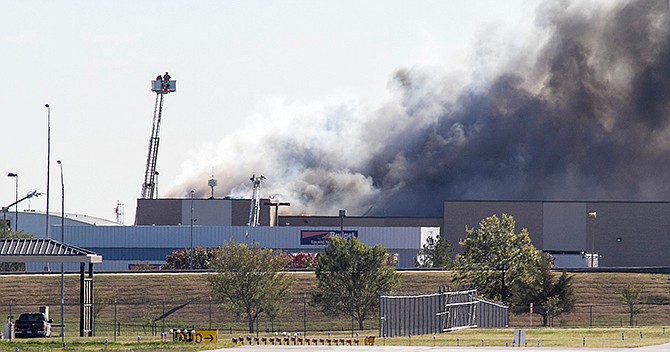 Firefighters try to put out a fire at Mid-Continent Airport in Wichita, Kan., Thursday. Oct. 30, 2014, shortly after a small plane crashed into the building killing several people including the pilot. 