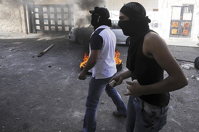 Palestinian youths throw stones during clashes with Israeli border police after Moatez Higazi was shot in east Jerusalem Thursday. 