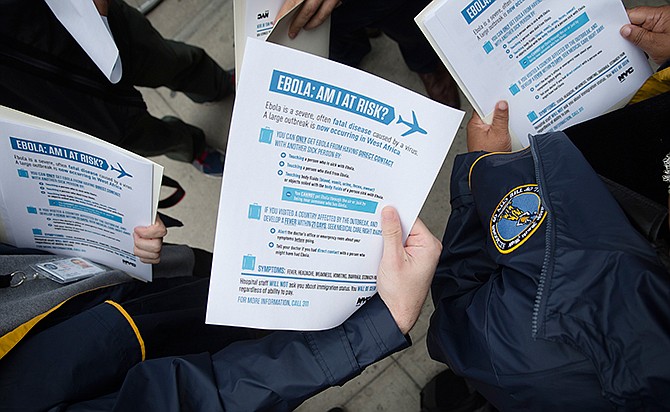 In this Oct. 24, 2014 file photo, members of the Brooklyn Borough President's office hand out fliers detailing the risks of Ebola outside The Gutter bowling alley in Brooklyn's Williamsburg neighborhood, in New York. Top medical experts studying the spread of Ebola say the public should expect more cases to emerge in the United States by year's end as infected people arrive here from West Africa, including American doctors and nurses returning from the hot zone and people fleeing from the deadly disease. No one knows for sure how many infections will emerge in the U.S. or anywhere else, but scientists have made educated guesses based on data models that weigh hundreds of variables, including daily new infections in West Africa, airline traffic worldwide and transmission possibilities. 