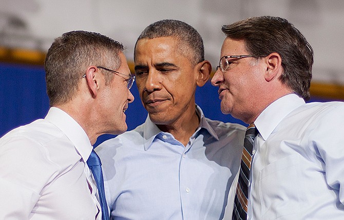 President Barack Obama, center, during a campaign event for U.S. Senate candidate Gary Peters, right, and gubernatorial candidate Mark Schauer, left, at Wayne State University, Saturday, Nov. 1, 2014 in Detroit, Mich. 