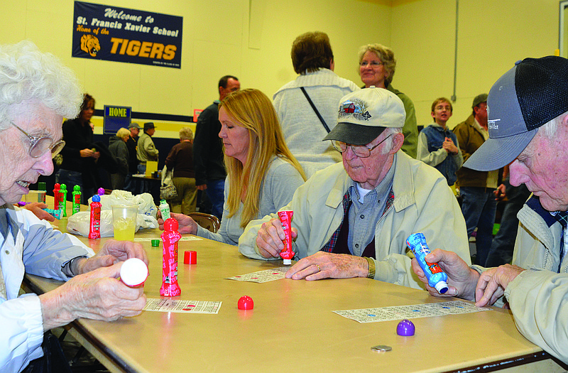 Mary Jane Henke plays bingo across from her husband, Fred (wearing glasses) at Sunday's annual St. Francis Xavier Harvest Festival. Now 87, she has been a member of the parish for basically her entire life, and says she enjoys getting together with family and friends at church events such as this.