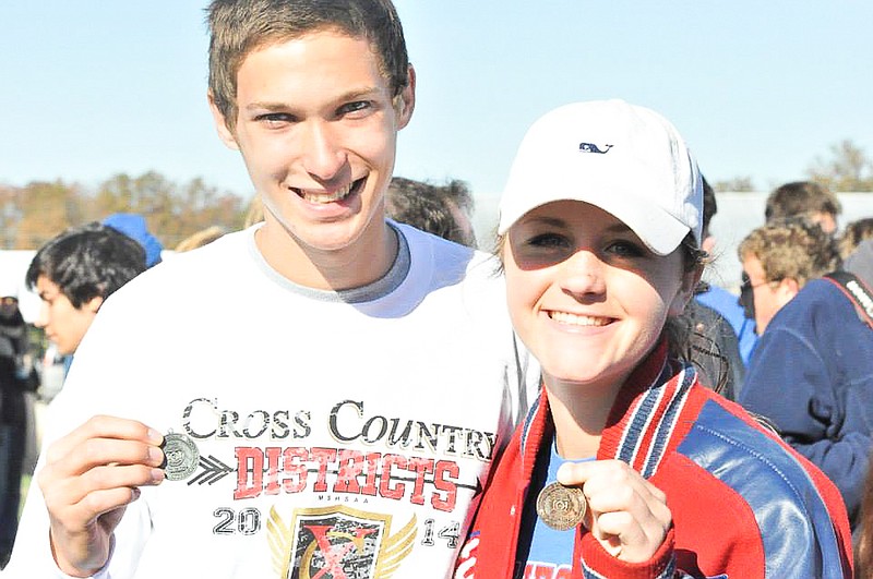 Adam Burkett and Katie Imhoff show their district medals. Both finished in the top 15 to advance them to the state level next Saturday.