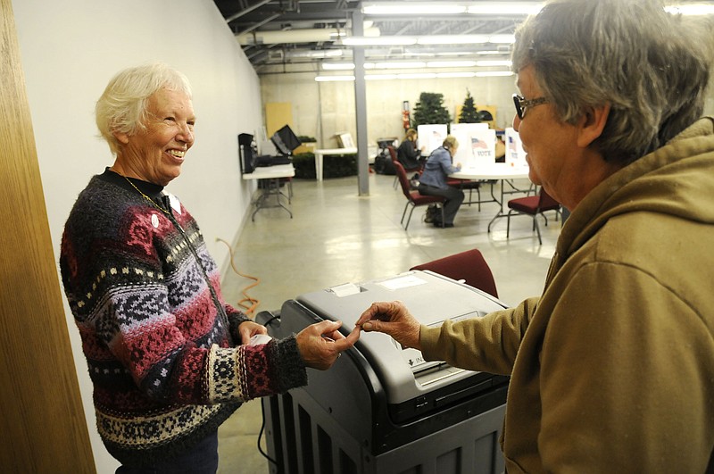 Election Judge Priscilla Stotts hands an "I voted" sticker to a Fulton resident after she casted her ballot Tuesday during the general election. Fulton's six precincts recorded a 33.41 percent voter turnout.