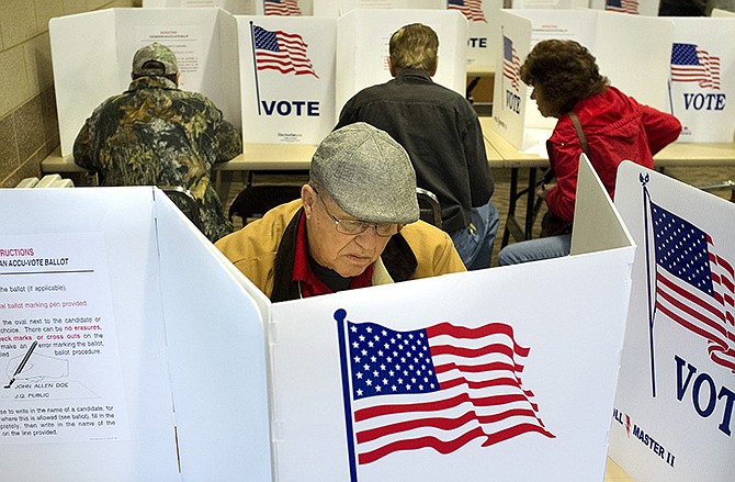 Dennis Frenzel cast his votes as other voters fill the booths during Election Day, Tuesday, Nov. 4, 2014 at the Arnold Recreation Center in Arnold, Mo. (AP Photo/St. Louis Post-Dispatch, Sid Hastings) 