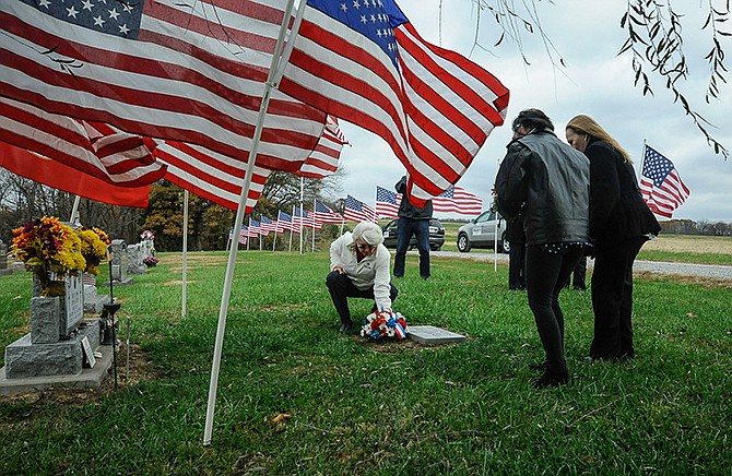 Gold Star Mother Donna Axelson places flowers at the memorial to Lance Cpl. Leon Deraps while other Gold Star mothers Maureen Murphy and Cindy Dietz-Marsh wait their turn. 