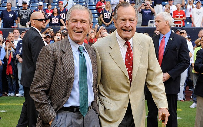This Oct. 25, 2009 file photo shows former Presidents George H. W. Bush, right, and George W. Bush before the Houston Texans NFL football game against the San Francisco 49ers in Houston. George W. Bush will be back in the public eye as he promotes "41," his upcoming book about his father, former President George H.W. Bush. Bush's interview with CBS newsman Bob Schieffer will air in two parts on Sunday, Nov. 9: the first on "Sunday Morning," the second on "Face the Nation." An interview with NBC's Savannah Guthrie airs on the "Today" show on Nov. 10.