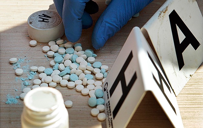In this Sept. 2, 2010 file photo a Franklin County police officer counts pills containing pseudoephedrine during a raid of a suspected meth house in Gerald, Mo. 
