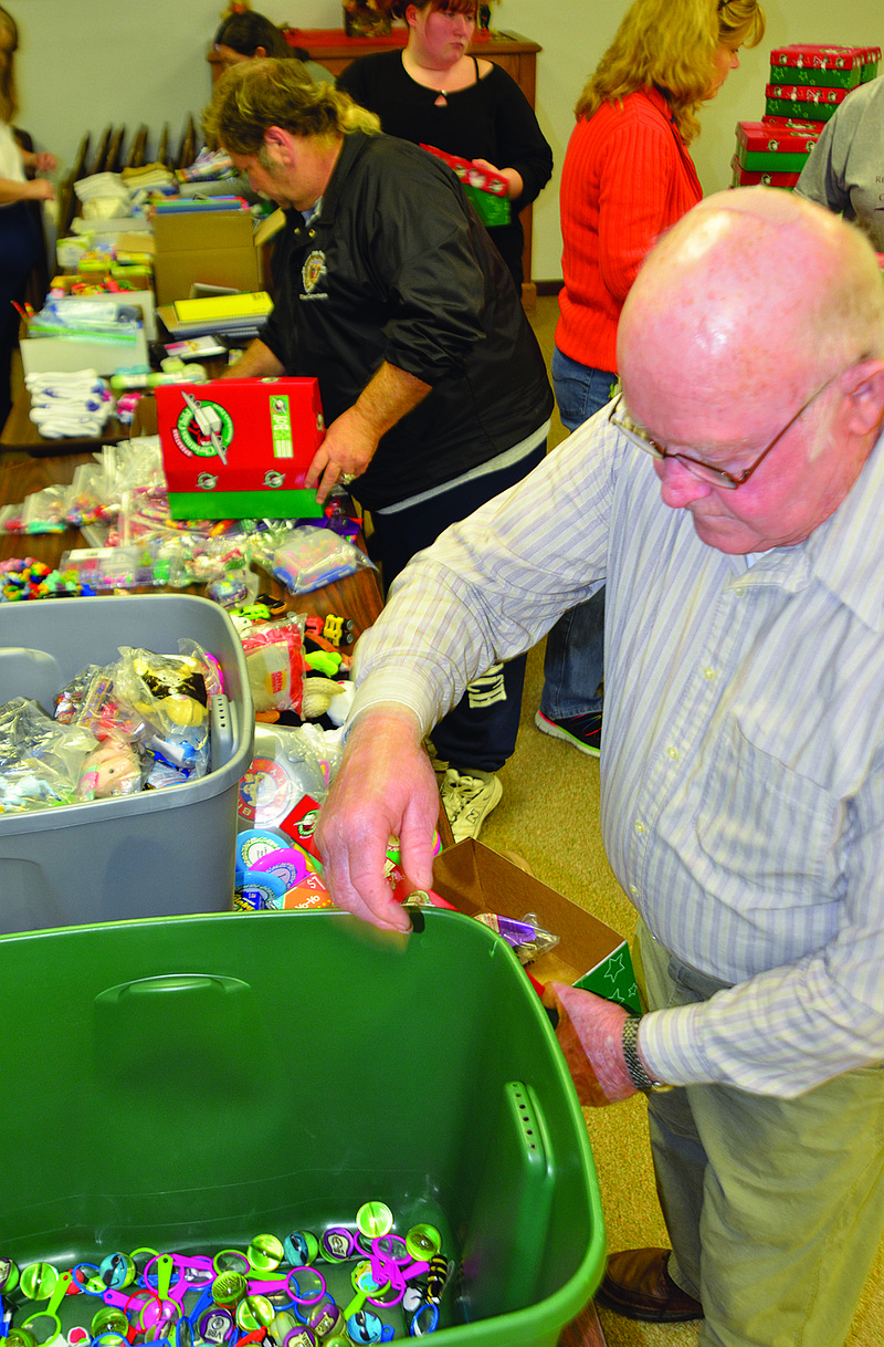 Harold Gabelsberger reaches into a box of toys to help fill a shoe box. He and about 15 others from Liberty Road Baptist Church filled some 55 boxes for their involvement in the Operation Christmas Child program.