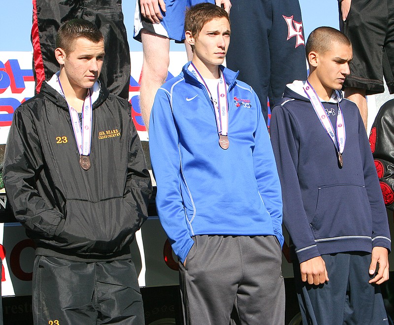 California junior Adam Burkett (center) wears his All-State medal during the awards ceremony for the Class 2 boys state finalists at Saturday's cross country meet in Jefferson City. Burkett finished 19th to earn his third state medal. He placed fourth as a freshman and 12th last season.