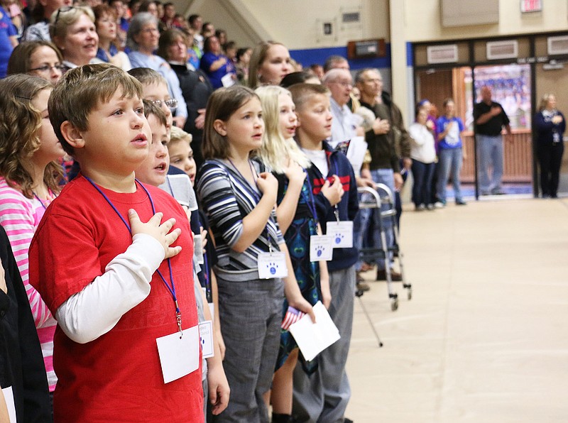 South Callaway students stand for the Pledge of Allegiance at the district's Veterans Day Assembly Tuesday morning in the High School's gym.