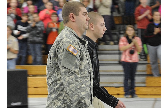 Missouri Army National Guardsman Kaleb Libbert was escorted by Russellville High School student Cory Libbert at the school's Veteran's Recognition Day Assembly Tuesday. Kaleb joined the Guard last month and Cory already has begun the enlistment process for after graduation. 
