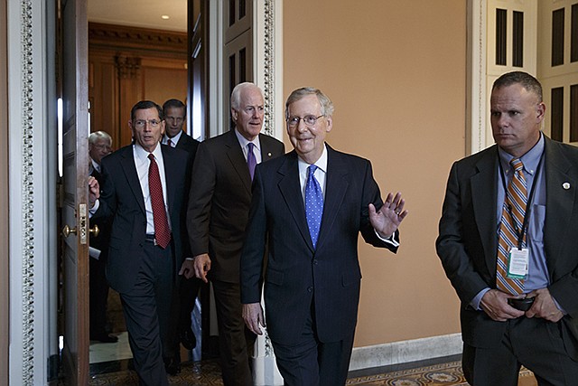Senate Minority Leader Mitch McConnell of Kentucky emerges from a closed-door meeting on Capitol Hill in Washington, Thursday, where he was chosen by acclamation to be the new Senate majority leader when the new Congress convenes in January. He is followed by Senate Minority Whip John Cornyn of Texas, and Sen. John Barrasso, R-Wyoming, Republican Policy Committee chairman, left. As majority leader, one of the most powerful positions in Congress, McConnell will set the Senate's agenda.