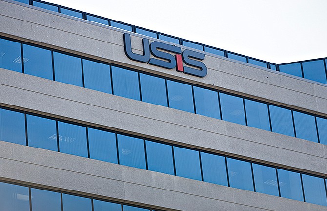 In this photo taken Oct. 17, 2014, the USIS building in Falls Church, Va. A cyber-attack similar to previous hacker intrusions from China penetrated computer networks for months at USIS, the government's leading security clearance contractor, before the company noticed the break-in, officials and others familiar with an FBI investigation and related official inquiries told The Associated Press. The breach compromised the private records of at least 25,000 employees at the Homeland Security Department and cost the company hundreds of millions of dollars in lost government contracts.