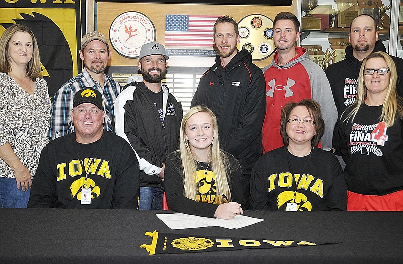 Brooke Rozier of Jefferson City High School (seated center) signs a letter of intent Thursday to play softball at the University of Iowa. Also seated are her parents, Troy and Cindy Rozier. Standing (from left) are travel coaches Kacey Marshall, Jeff Hardy and Ryan Traylor, Lady Jays assistant coaches Zach Miller, Kyle Lasley and Brian Ash, and Lady Jays head coach Lisa Dey.