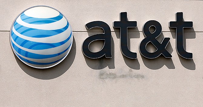 In this May 14, 2014 file photo, an AT&T logo on a store in Dedham, Mass. 