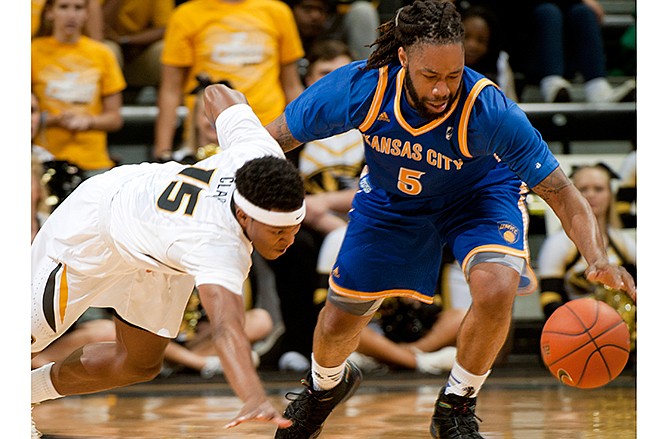 Missouri-Kansas City's Reese Holliday, right, and Missouri's Wes Clark reach for a loose ball during the first half of an NCAA college basketball game Friday, Nov. 14, 2014, in Columbia, Mo. 