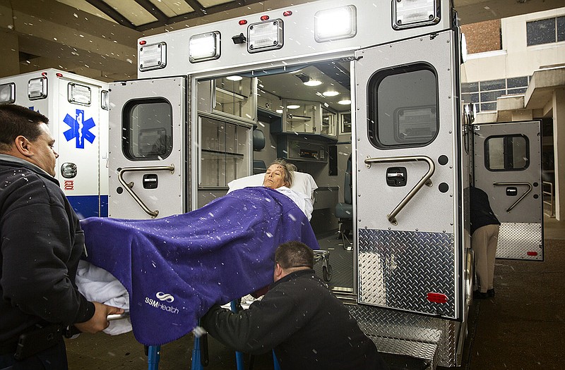 Paramedics move one of the last St. Mary's patients from the old hospital to the new building Sunday morning. 
