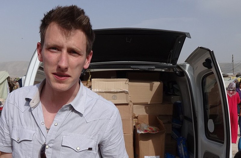 This undated file photo provided by the Kassig Family shows Peter Kassig standing in front of a truck filled with supplies for Syrian refugees. A new graphic video purportedly produced by Islamic State militants in Syria released Sunday claims U.S. aid worker Kassig was beheaded.