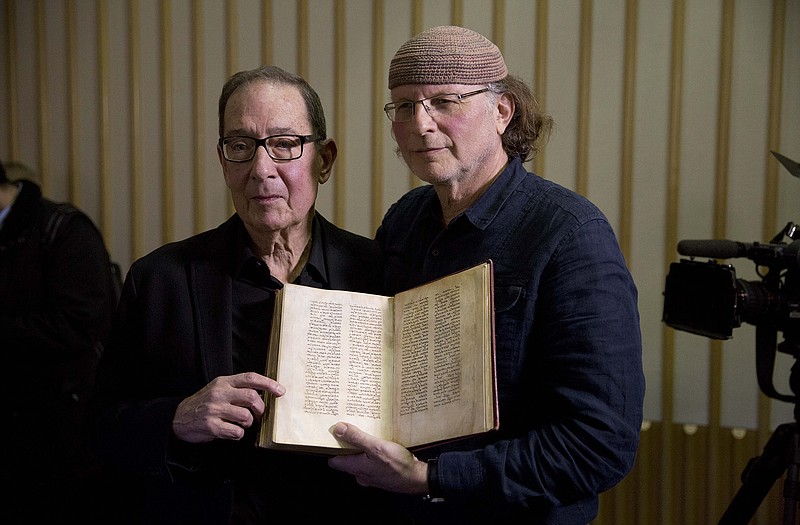 Canadian-Israeli documentary film-maker and writer Simcha Jacobovici, right, and religious studies professor Barrie Wilson, the authors of "The Lost Gospel" pose for photographs after giving a press conference with a copy of an ancient manuscript at the British Library in London.  A researcher who has attracted attention and criticism with revisionist Biblical theories says he has found new evidence that Jesus was married to Mary Magdalene and that early Christians considered her a deity.  Jacobovici says an ancient manuscript in the British Library relates the story of Jesus, his wife Mary Magdalene and their children. 