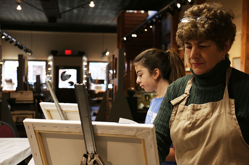 Karen Mertens paints during Janis Burgin's oil painting class at Art House on Tuesday.
