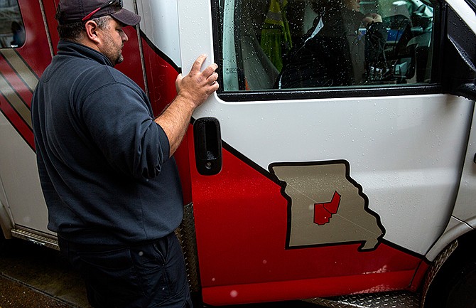 A Mid-Mo Ambulance employee prepares to board an ambulance Sunday morning while helping move patients from the old St. Mary's hospital to the new location on Mission Drive in Jefferson City. 

