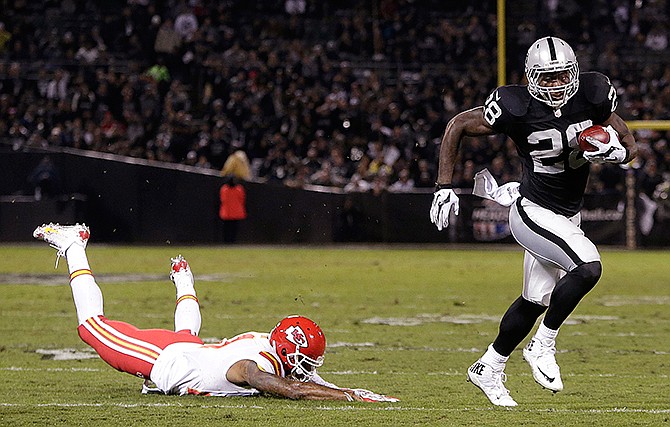 Oakland Raiders running back Latavius Murray (28) runs past Kansas City Chiefs cornerback Sean Smith on an 11-yard touchdown run during the first quarter of an NFL football game in Oakland, Calif., Thursday, Nov. 20, 2014.