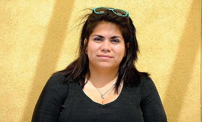 Astrid Silva poses as she waits for her number to be called to renew her passport at the Mexican Consulate in Las Vegas in this Friday, June 22, 2012 file photo. The young woman who has led immigration reform efforts buried her face in her father's shoulder, standing side-by-side against a wall, as the president mentioned the time when Silva couldn't return to Mexico to be at her grandmother's funeral. The 26-year-old's tears didn't abate as she went from interview to interview in front of cameras and microphones in a crowded Las Vegas office to tell her story once more, seconds after Obama finished telling the country about his plan to offer protections to nearly 5 million immigrants, including deferring deportations for some.