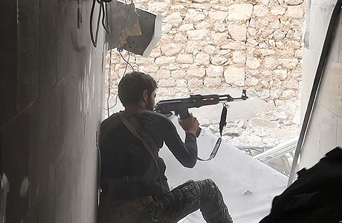 In this undated photo posted Nov. 4 by the Raqqa Media Office of the Islamic State group, a militant extremist group, shows an Islamic state group fighter in Kobani, Syria. For a force that has built its reputation on projecting an aura of momentum and invincibility, the prolonged stalemate in Kobani is a setback for Islamic State militants with potential implications in terms of recruitment and support. 