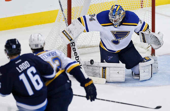 St. Louis Blues goaltender Jake Allen stops the shot from Winnipeg Jets' Andrew Ladd (16) as Blues' Kevin Shattenkirk (22) defends during first period NHL hockey action in Winnipeg on Sunday, Nov. 23, 2014.
