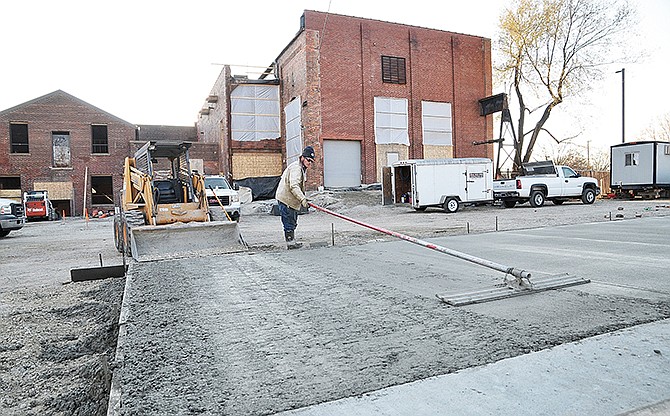 Progress continues at the site of the former Missouri Power and Light power plant location just off West Main Street in Jefferson City's Millbottom area. Tylor Marvel smooths the wet cement after he and co-workers from Concrete Foundation Construction Company poured concrete for a parking lot Thursday.