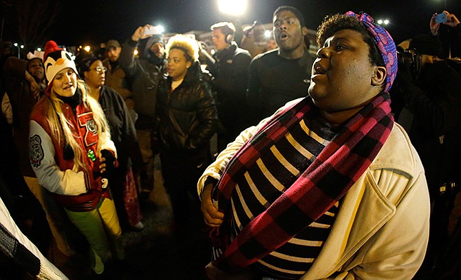 Protesters gather in front of the Ferguson Police department Monday, Nov. 24, 2014, in Ferguson, Mo., before the announcement of the grand jury decision about whether to indict a Ferguson police officer in the shooting death of Michael Brown.