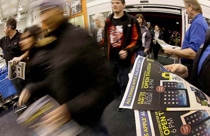  In this Thursday, Nov. 28, 2013, file photo, shoppers enter a Best Buy as the store opens on Thanksgiving Day, in Overland Park, Kan. 