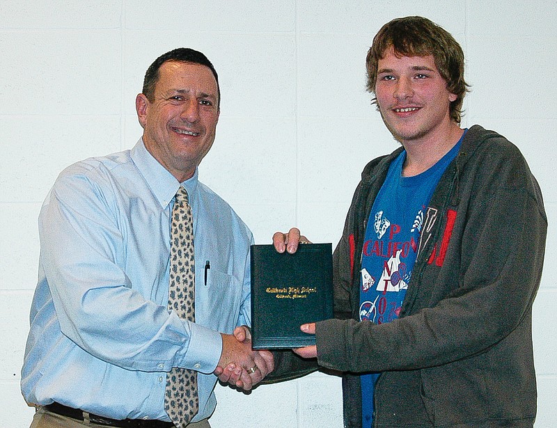 California School Board President Jay VanDieren, left, presents a high school diploma to Gabriel Meyer a the school board meeting on Wednesday, Nov. 19. Meyer earned the diploma through the Missouri Option Program.