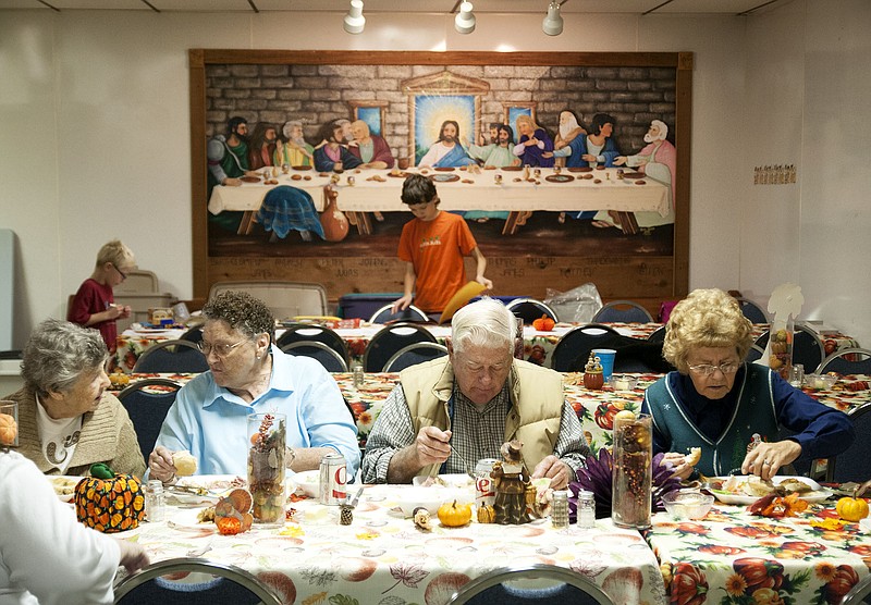 Patrons of the annual New Bloomfield community Thanksgiving dinner eat their meal and visit with friends inside the town's United Methodist Church. The tradition has continued for nine years now, with about 125 people total being served in most recent years.
