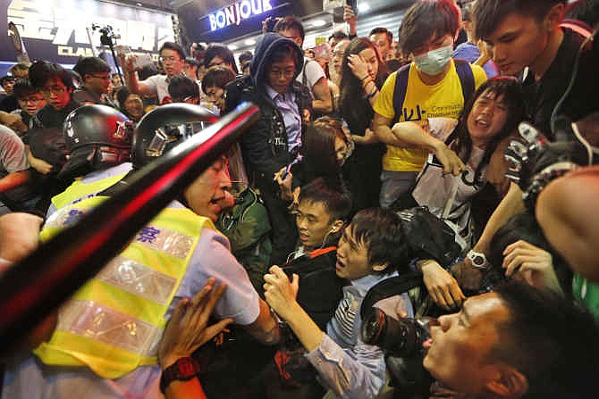 Police officers stop the protesters blocking the road after police cleared barricades and tents in Mong Kok district of Hong Kong Wednesday Nov. 26, 2014. Police arrested key student leaders of Hong Kong's pro-democracy protests on Wednesday as they cleared barricades in one volatile district, throwing into doubt the future of a 2-month-old movement seeking free elections in the former British colony.