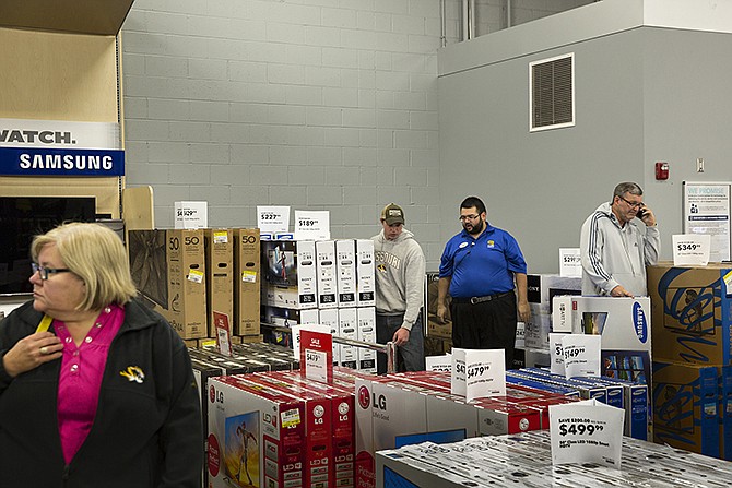 Shoppers browse discounted televisions at Best Buy Friday morning during the second day of the store's Black Friday sale. 