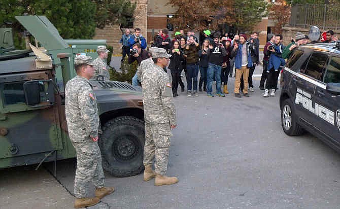 Protesters take pictures of members of the Missouri National Guard stationed outside West County Mall Friday, Nov. 28, 2014, in Des Peres, Mo. Demonstrators disrupted holiday shopping at several locations around St. Louis on Sunday, forcing the closure of a large shopping mall for about an hour amid a protest triggered by a grand jury's decision not to indict the police officer who fatally shot Michael Brown in nearby Ferguson.