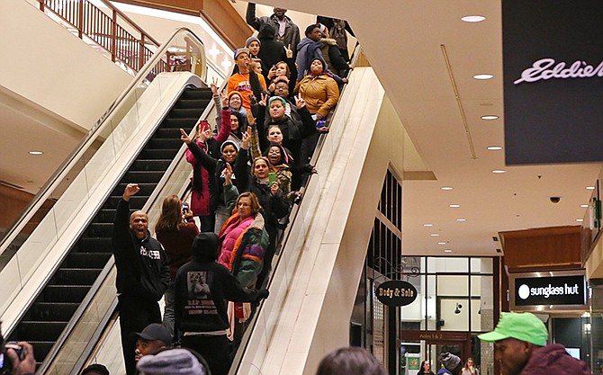 Protesters of the grand jury decision in the Michael Brown shooting chant slogans at the St. Louis Galleria mall on Wednesday evening, Nov. 26, 2014, in Richmond Heights, Mo. They stayed in the mall for about 15 minutes and then left peacefully without confrontation with a large police presence. On Thursday night, protesters targeted their brief interuptions at a Target and various Walmart stores in the St. Louis area.