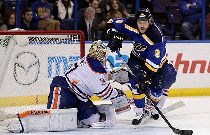 Edmonton Oilers goalie Ben Scrivens, left, trips up St. Louis Blues' Steve Ott (9) in the second period of an NHL hockey game, Friday, Nov. 28, 2014, in St. Louis. 